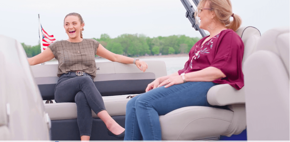 two women talking and laughing on a boat